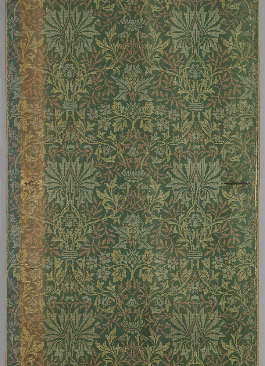 A woven silk panel combines repeating leaves and flowers in green and gold.