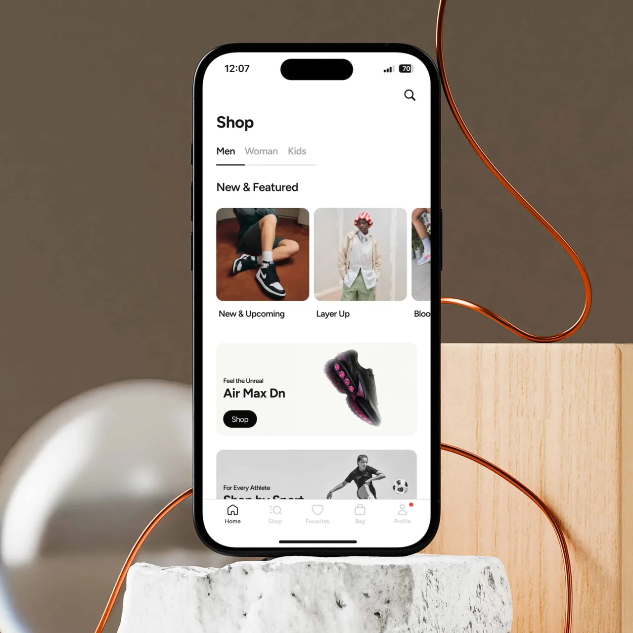 iPhone 15 displaying a shopping app with categories for men, women, and kids and featured sneaker promotions.