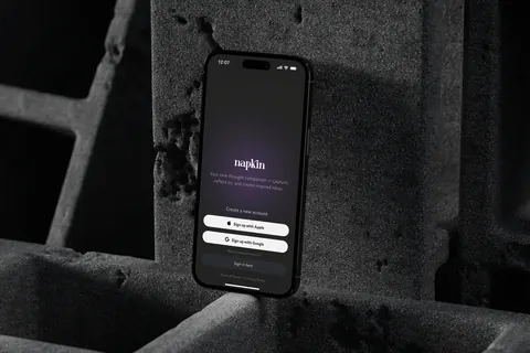 A iPhone 16 displays the Napkin app sign-up screen with options to sign up using Apple or Google.